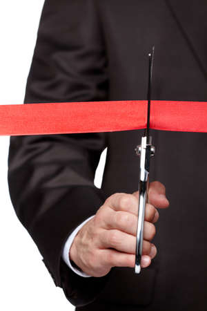 A businessman cutting a ribbon with scissors, isolated on white