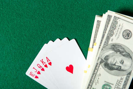 Royal Flush poker card sequence with currency on a green table. Challenge to the casino