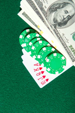 Royal Flush poker card sequence with green chips and money on a green table. Risky entertainment of...