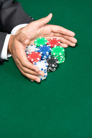 Poker player going all in pushing his chips forward. Risky entertainment of gambling