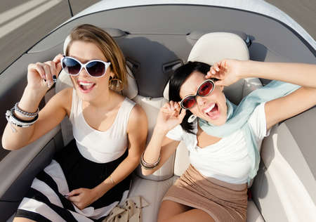 Top view of happy women with sunglasses sitting in the cabrioletの写真素材