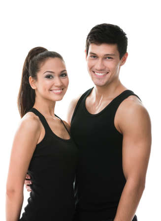 Two sportive people in black sportswear embrace each other, isolated on whiteの写真素材
