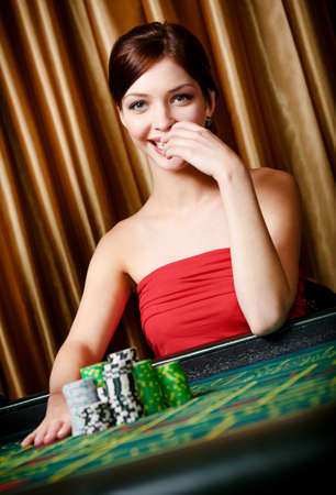 Smiley woman with piles of chips at the roulette table at he casinoの写真素材