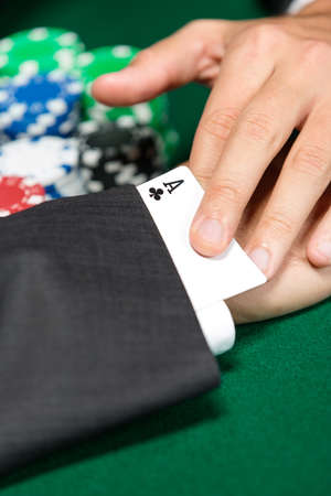 Poker player cheats with card from the sleeve. Risky entertainment of gambling