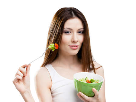 Dieting woman eats fresh salad in salad bowl, isolatedの写真素材