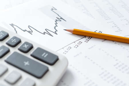Close up of business stationery: calculator, graphs, pencilの写真素材