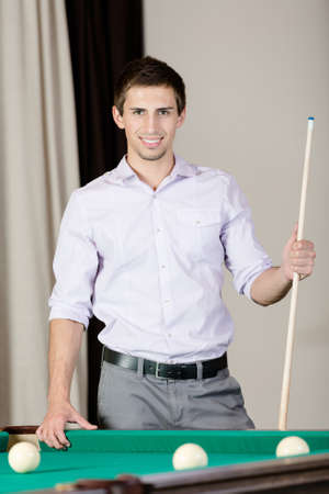 Man standing near billiard table  Spending free time on gambling