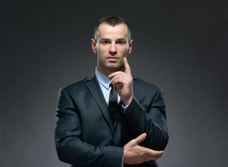 Portrait of making forefinger gesture businessman wears business suit and black tie