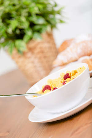 Close up view of plate with muesli and strawberry at the kitchen table