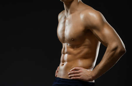 Close up of naked male's chest, isolated on black