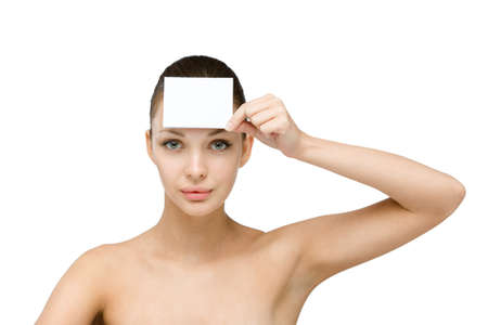 Girl hands white and blank copyspace card in front of her forehead, isolated on whiteの写真素材