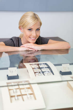 Consultant at the window case with rings at jeweler's shop. Concept of wealth and luxurious lifeの写真素材