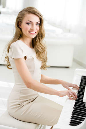 Portrait of woman sitting and playing piano. Concept of music and artの写真素材