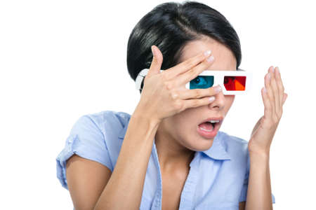 Scared girl in 3D glasses watches film through hands, isolated on whiteの写真素材