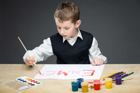 Portrait of little boy drawing energy formula with paints and pencils. Concept of arts and hobbyの写真素材