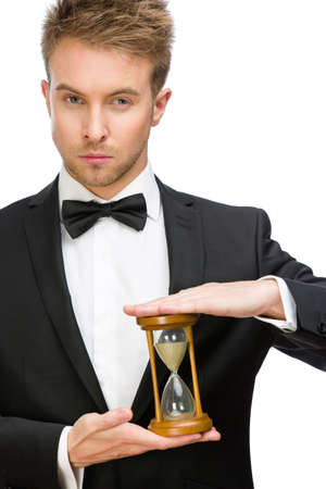 Half-length portrait of businessman keeping hourglass, isolated on white