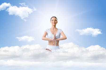 Young woman in a lotus position on the sky during meditationの写真素材