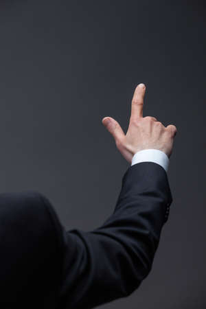 Close up of pointing hand, isolated on grey background. Concept of leadership and business success
