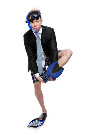 Businessman wearing suit and goggles with snorkel takes off fins, isolated on whiteの写真素材