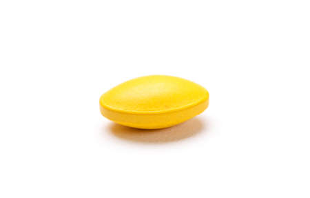 Yellow pill, isolated on whiteの写真素材