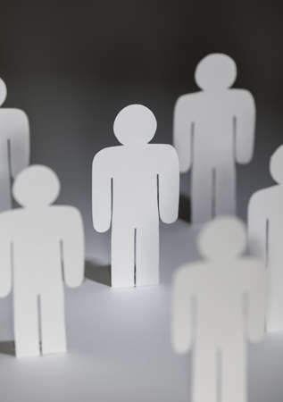 Close up of group of standing papermen. Lots of copies of one paper man. Concept of teamwork, partnership and supportの写真素材