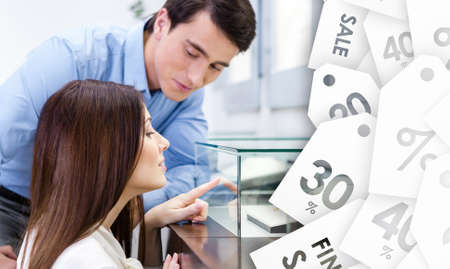 Girl with male selects expensive ring, saving coupons background. Concept of wealth and luxurious lifeの写真素材