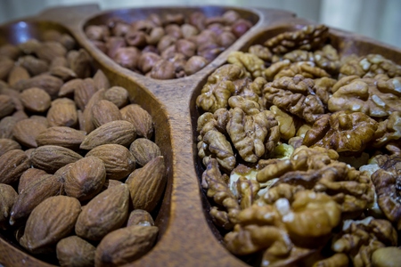 Almonds, nuts and hezelnuts in wooden bowlの写真素材