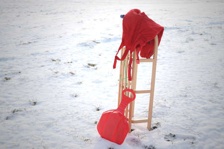 red salopettes and sledge in snowの写真素材