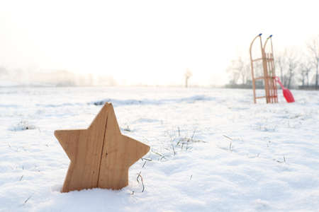 wooden star in snow with sleighの写真素材