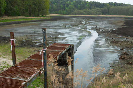 Bridge that leads to nowhere on a drained pondの写真素材