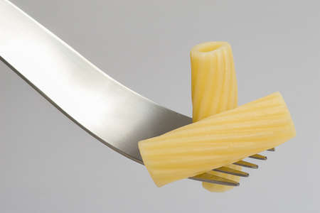 Two rigatoni on a modern forkの写真素材