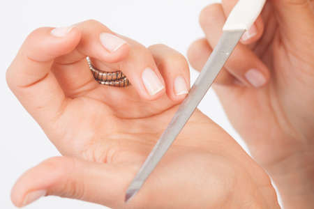 Hands of a young woman filing nailsの写真素材