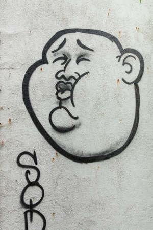 Graffiti of a fat Asians on gray wallの写真素材