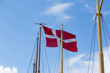 Danish flag, Dannebrog, on a sailing ship in the harbor of Svendborgの写真素材