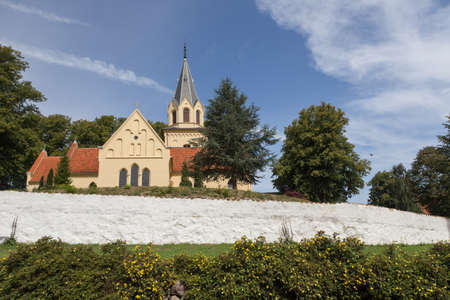 Yellow church cemetery behind white wallの写真素材