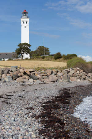 Lighthouse of Langeland behind rocky beach of the Baltic Seaの写真素材