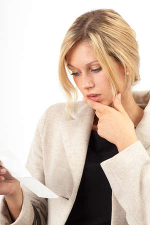 Young woman looking shocked at an invoiceの写真素材