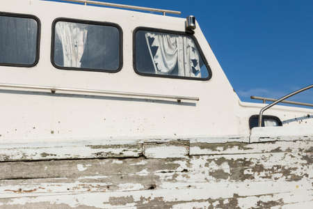 Cabin of a weathered motorboat with curtains and railsの写真素材