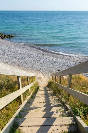 Steep wooden staircase that leads to a rocky beach at the southern tip of Denmarkの写真素材