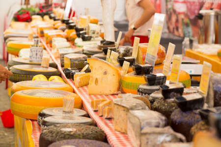 Large supply of various types of cheese on a market stallの写真素材