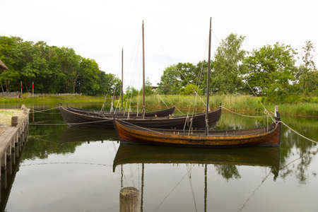 Three historic sailboats at the wharf on a lakeの写真素材