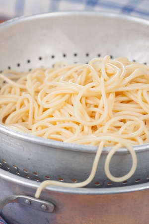 Spaghetti in a metal screenの写真素材