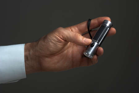 A flashlight with solar cell and three LEDs in male hand.