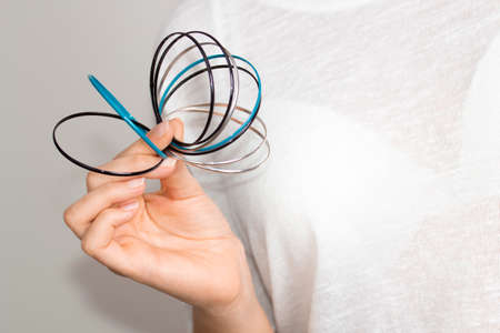 Young woman hand with cyan, silver and black rings