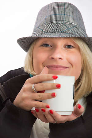 Portrait of young woman with a hat and a white cupの写真素材