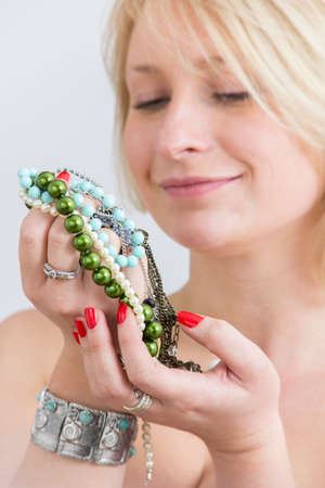 Young woman face and hands with red nails and jewelryの写真素材