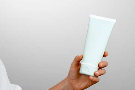 Close view of girls hand with a white tubeの写真素材