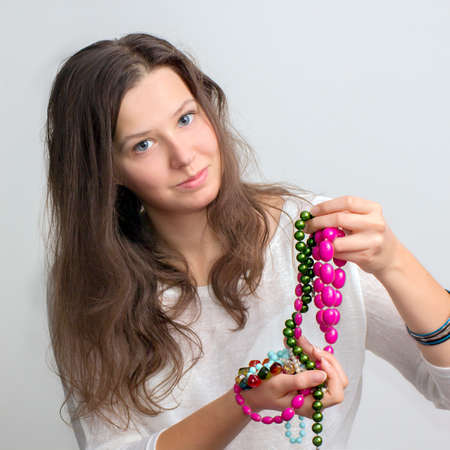 Portrait of young girl with a jewelry in a handsの写真素材