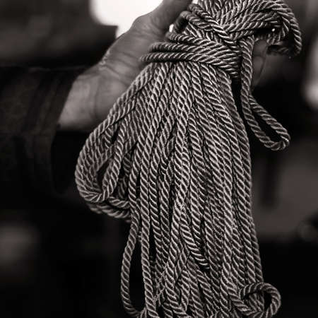 Close view of a bundle of rope in a mans handの写真素材