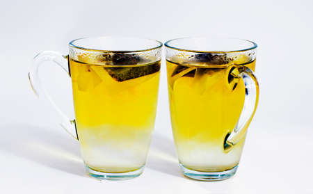 Close view of a glass of green tea with a teabagの写真素材